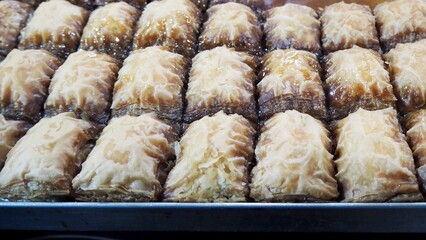 Closely chopped prepared pieces of honey baklava. Eastern sweets. Lactose-free. Market, Eastern food festival. Side view.