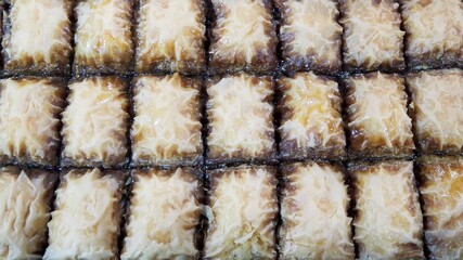 Closely chopped prepared pieces of honey baklava. Eastern sweets. Lactose-free. Market, Eastern food festival. Top view.