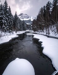 Icy river flows through snowy forest