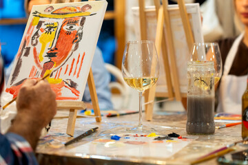 Art & Wine workshop. Person painting abstract art during wine workshop