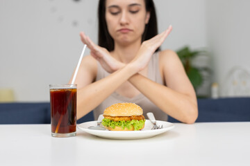 women rejecting fast food and soda with crossed arms gesture, promoting healthy eating habits, dietary choices or lifestyle change concepts for health related content.