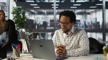 Black man general manager connects with his team via video call, reviewing business operations and strategic objectives. Using online communication to enable efficient decision making. Camera B.