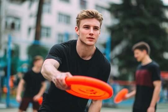 Young man playing frisbee with friends outdoors