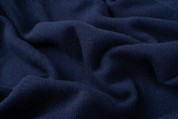 Navy blue merino wool sweater texture as background. Top view.