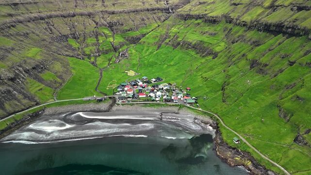 Nestled between lush green mountains and the ocean, Tjornuvik village in the Faroe Islands showcases stunning landscapes and traditional architecture.