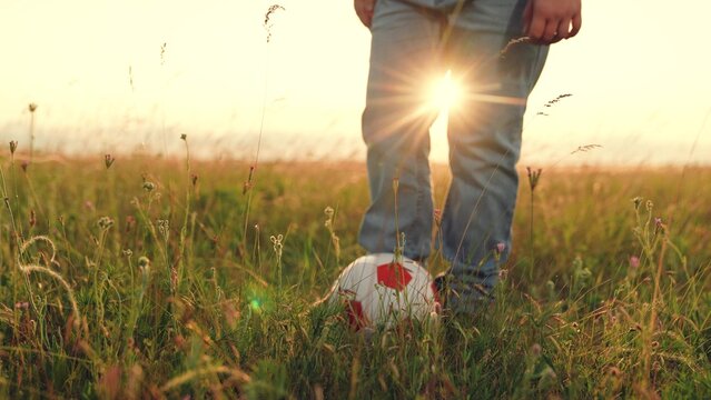 People nature, child kid kicking soccer ball sunset, child playing ball lawn outdoors, playground park, schoolboy playing, summer field game, warm light, slow living, simple outdoor joy. country - Powered by Adobe