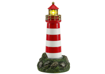 Isolated vintage miniature light house model with a light shining in red and gold tones