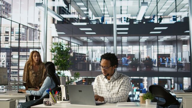 Skilled businessman at his office desk working on report writing, data analysis and deadline management. Male executive looking to expand the enterprise globally, multitasking at job. Camera B.