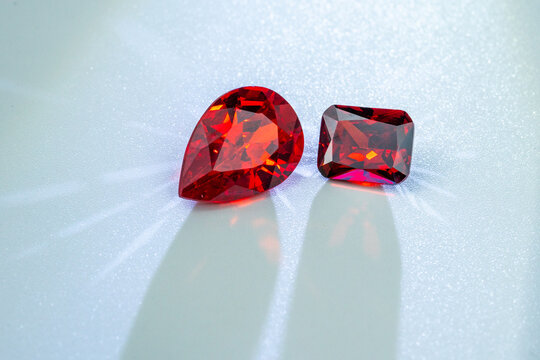 Sparkling red gemstones with brilliant facets placed on a light background, symbolizing luxury, passion, and elegance, perfect for jewelry, fashion, or decorative design concepts.