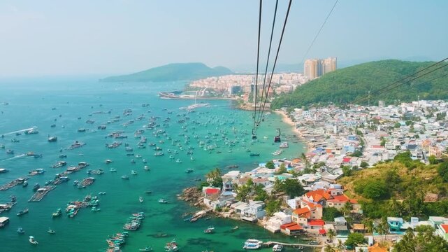 Aerial view of An Thoi harbor with coastal fishermen village, fishing boats, turquoise sea and modern cable car ride on Phu Quoc island, Vietnam. Modern Hon Thom cable car cabin