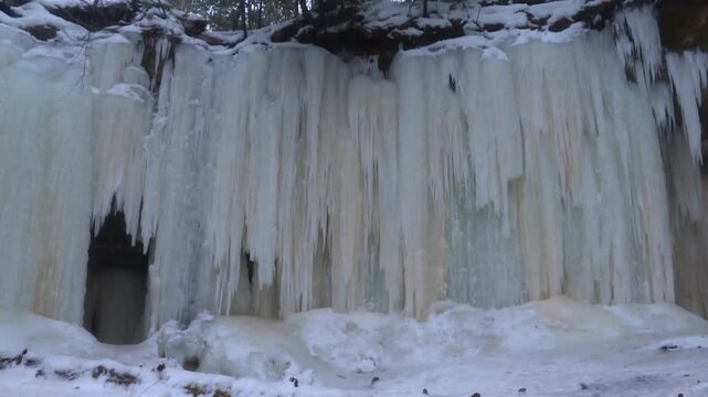 Melting Snow Over A Cliff At Rock River Canyon Ice Caves Near Eben Junction In Upper Peninsula, Michigan. Tilt-down Shot