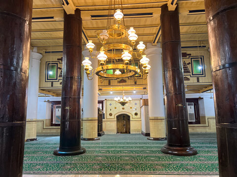Interior of Great Mosque of Demak Indonesia, Historic Javanese Islamic Architecture with Wooden Pillars and Golden Chandeliers