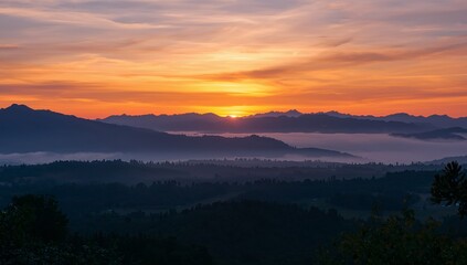 Fototapeta premium Aerial Vista at Twilight A Gradient of Mountains and Warm Hues Filling the Sky.
