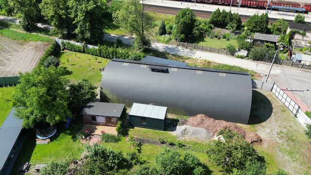 Nowoczesny dom na osiedlu z widokiem na błękitne niebo. Jasna elewacja, duże okna i prosta forma podkreślają wsp&oacute;łczesny styl architektury. Ujęcie oddaje harmonię między nowoczesnym budownictwem a spo
