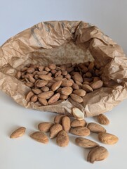 A minimalist composition of almonds spilling from a textured paper pouch. Simple, clean, and beautifully organic.
