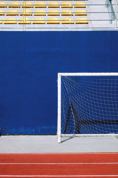 Soccer goal on the blue wall of a sports arena with bleachers