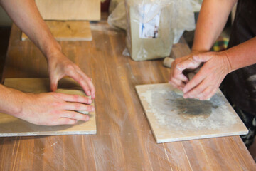 Hands Kneading Clay on Wooden Table in Pottery Workshop