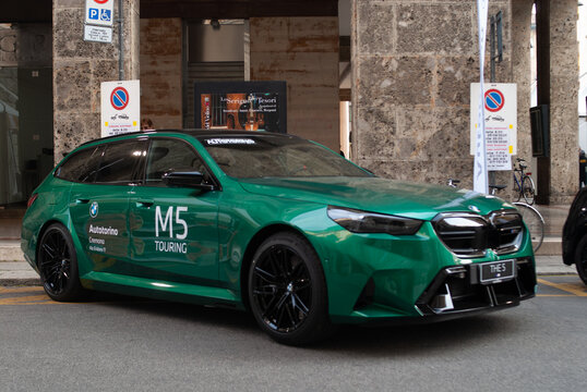 BMW M5 Touring car showcasing modern automotive design and hybrid power technology on a city street