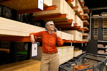 Woman shopping for materials in a home improvement store while talking on the phone