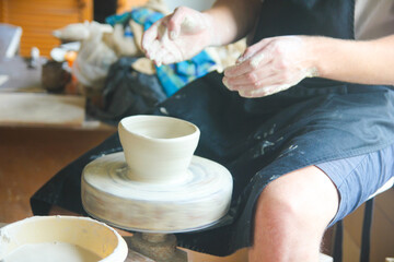 Hands of Potter Working with Clay on Pottery Wheel in Ceramic Workshop