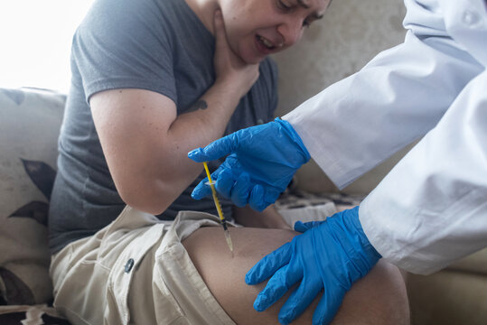 A man injects himself with adrenaline into his thigh during anaphylactic shock. First aid for allergies, emergency medical care for an allergic reaction.