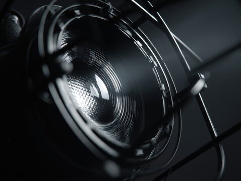 Close-up studio shot of a modern microphone showing the capsule and suspension mount in dark monochrome