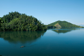 lake in the mountains: "Fishermen are fishing in the bay with a backdrop of reflections of mountains and mangrove forest" - East Halmahera, Indonesia