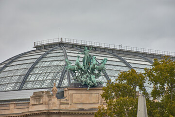 Bronze quadriga of Harmony triumphing over Discord atop the Grand Palais in Paris with a gray sky in the background