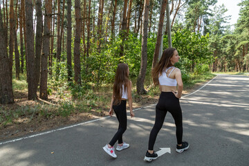 Obraz premium Mother and daughter walking in the forest on a summer day.