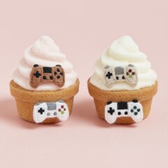 Two cupcakes decorated with video game controllers in studio shot on pink background sweet treats for gamers