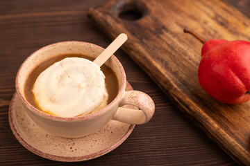Сhocolate Ice cream in white glaze, cup of coffee, on brown wooden, side view, close up, selective focus