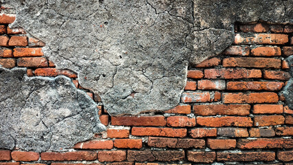old cracked concrete wall with exposed red brick texture. vintage grunge wall background showing aged plaster peeling off