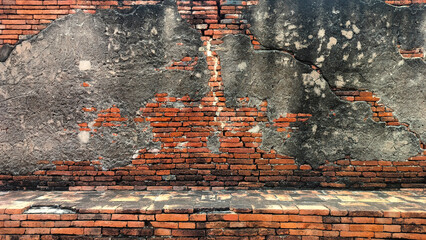 old cracked concrete wall with exposed red brick texture. vintage grunge wall background showing aged plaster peeling off