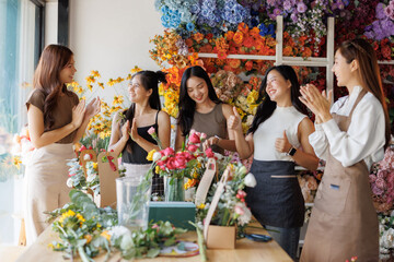 Young asian women celebrating success in flower shop