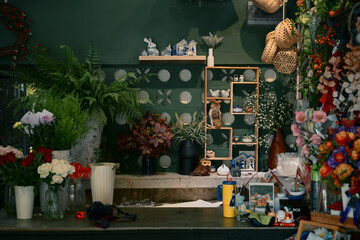 Cozy flower shop interior filled with plants, floral materials, and decorative crafts, creating a warm creative workspace