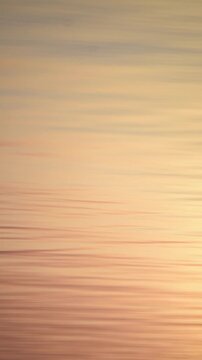 Calm sea surface in evening sunlight, quiet waves close-up, abstract background.