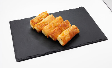 Golden Fried Spring Rolls Arranged On Black Slate Plate For Appetizer Serving