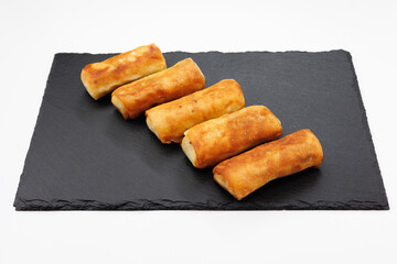 Golden Fried Spring Rolls Arranged On Black Slate Plate For Appetizer Serving