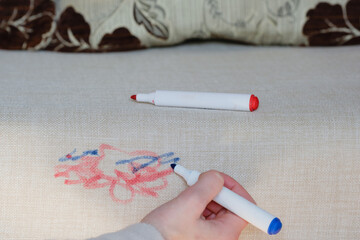 Blue marker in vibrant colors used to create abstract designs on a textured fabric surface.The surface light fabric shows intricate texture as the cleaning care. Daily stains concepеt