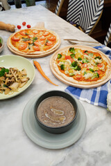 Delicious food and drinks beautifully presented on a table, including pizza, soup and mushrooms