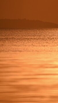 Calm quiet water surface on the Dnieper River, evening time, orange light from the setting sun.
