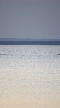 Fishing boat on the sea, large water area and dark sky, bright sunlight, blue water.