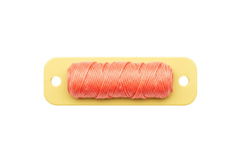 Isolated spool of salmon-colored embroidery floss on a plastic card for crafts projects