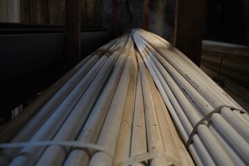 Obraz premium Stack of PVC Pipes in Warehouse with Low Light