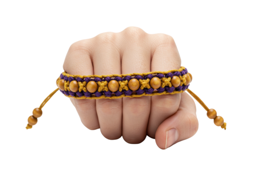Isolated hand wearing braided bracelet with wooden beads and purple and yellow decorative design