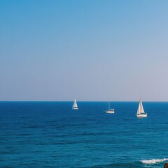 Fototapeta premium Three sailboats sailing on the deep blue sea waters on a sunny day aerial view seascape scene summer vacation travel destination