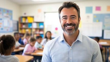 Warm and approachable male elementary school teacher smiling directly at the camera with engaged students in a bright, colorful classroom