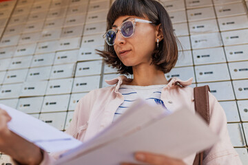 Close-up of envelopes. Girl receiving mail, looking at correspondence notification.