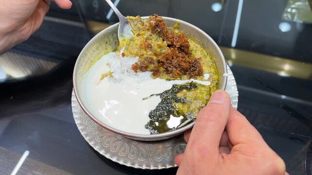 Traditional Iranian food delicious ash stew haleem garnished with fried garlic and mint kashk is a healthy lentil soup nutritious meal halal dish Ramadan Iftar dinner Tehran Middle Eastern gastronomy