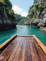 Boat ride through Ha Long Bay Vietnam point of view from wooden deck on emerald water surrounded by limestone cliffs